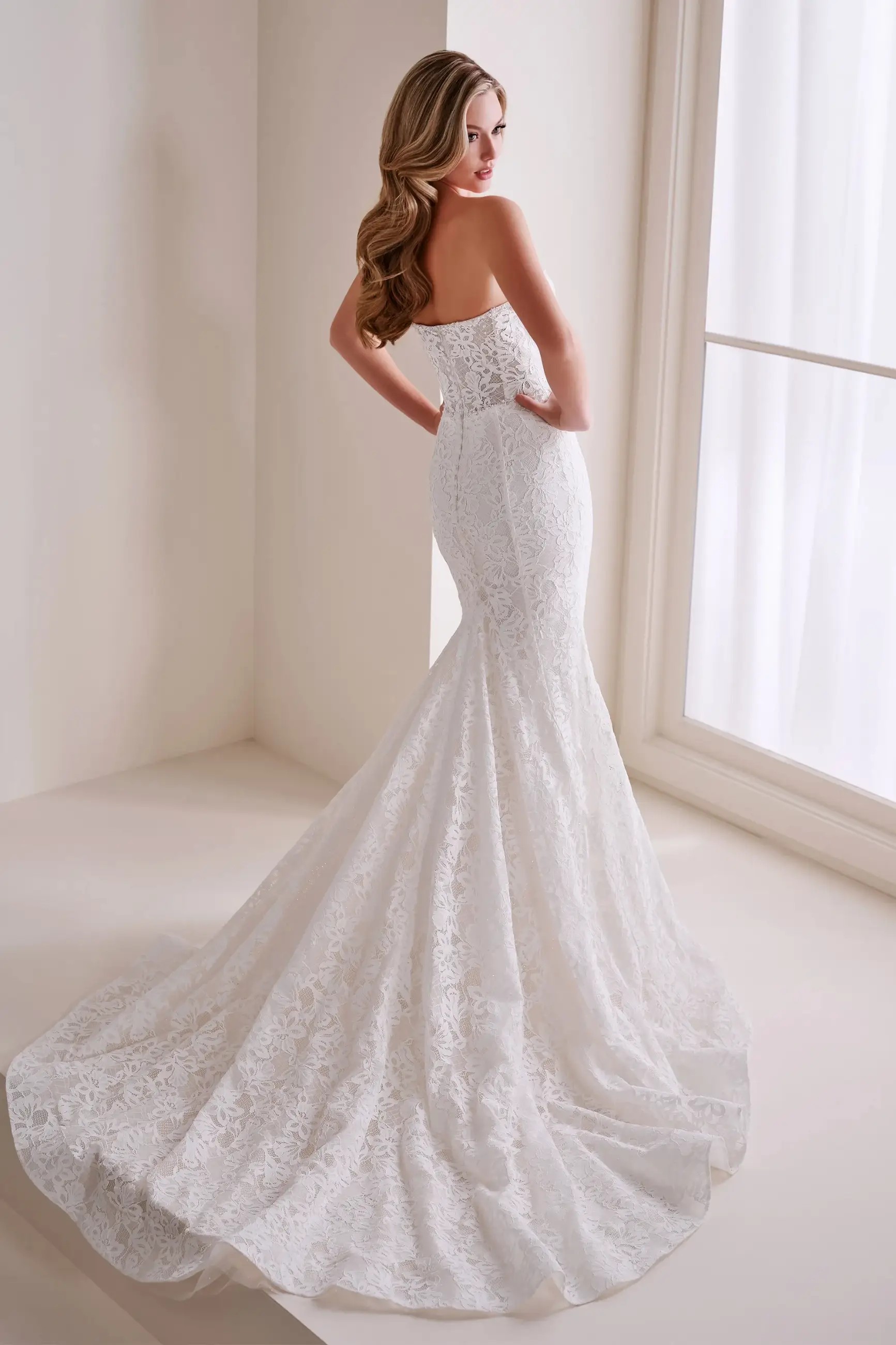 Model is wearing a drop waist mermaid wedding dress by enchanting by mon cheri
