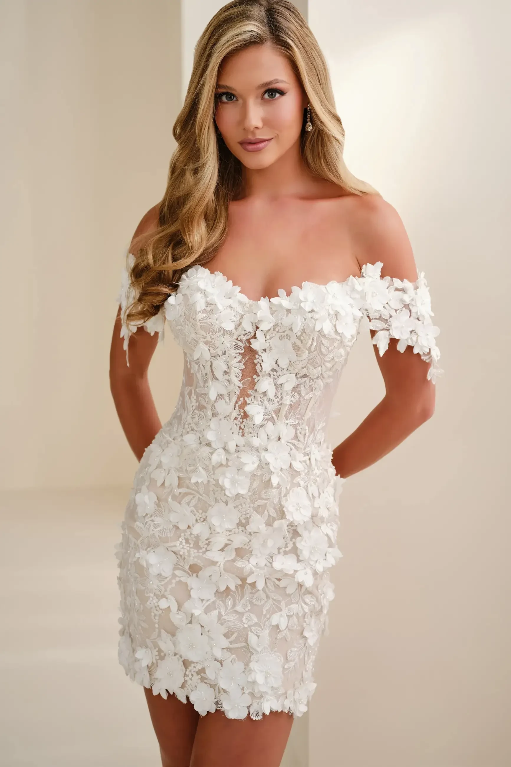 A woman in an elegant, off-shoulder, floral lace wedding dress is smiling gently. The dress features intricate flower patterns, conveying a romantic tone.
