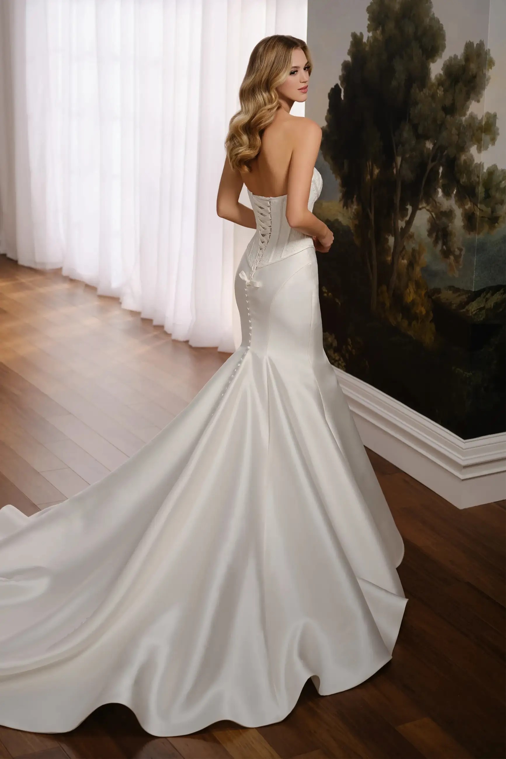 Model is wearing a trumpet wedding dress with a dropped waist, lace bodice, and mikado skirt by martin thornburg