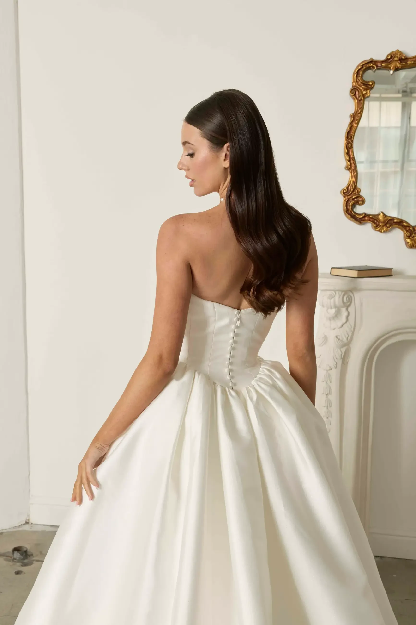 model is wearing a strapless ball gown wedding dress