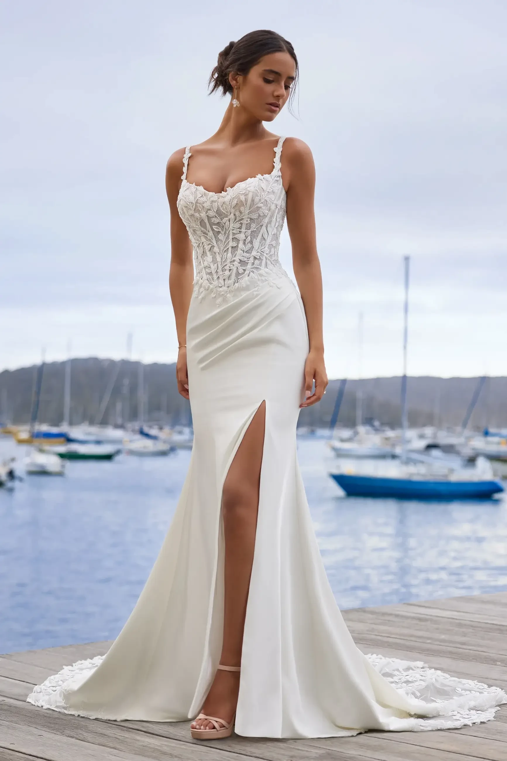 model is wearing a sleeveless open back fit and flare wedding dress